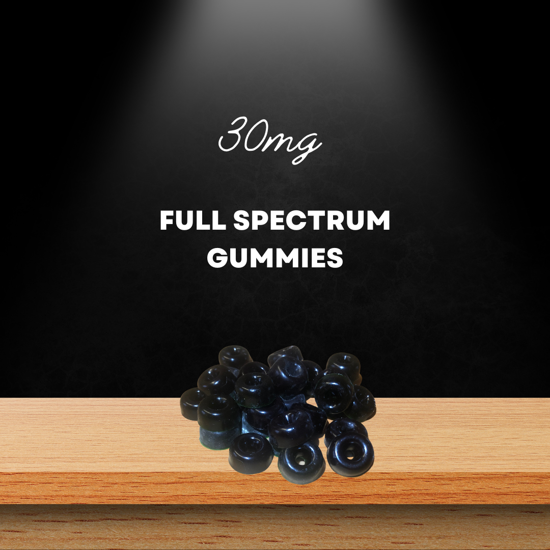 A display of 30 mg full-spectrum CBD gummies on a wooden surface, highlighted under a spotlight with a dark background.