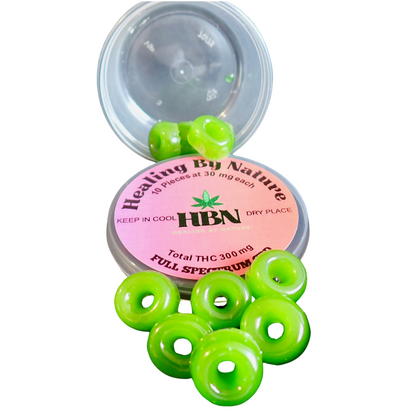 
An open container labeled "Healing By Nature" with 10 green gummies spilled out. The label states 30mg per gummy, totaling 300mg THC