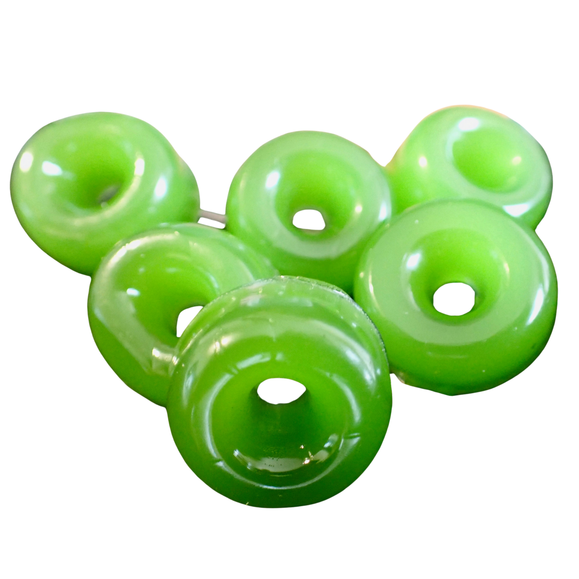 Close-up of six green, circular gummies with a hole in the center, resembling small rings or doughnuts. They are smooth and shiny.